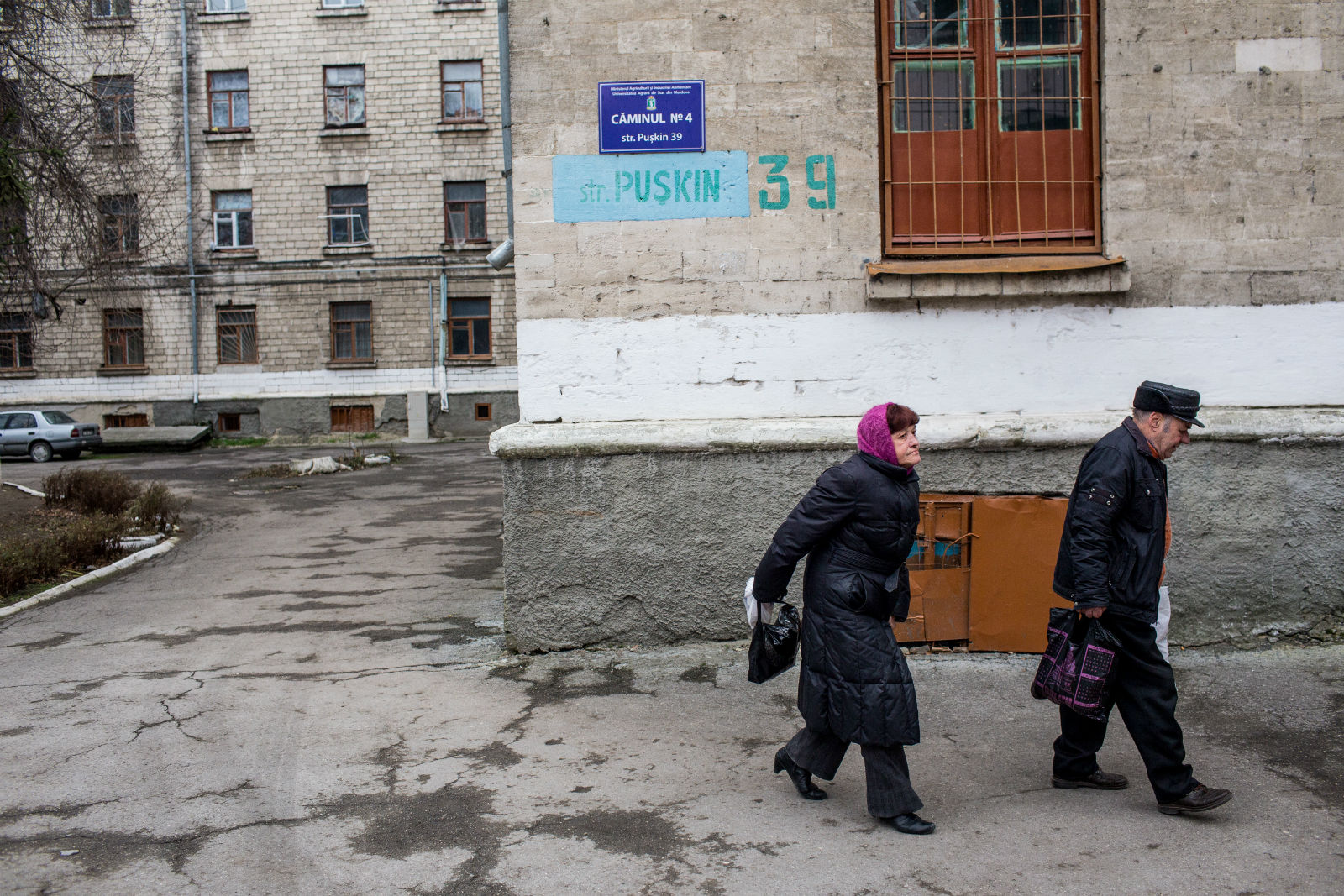 An elderly couple walks by in the center of Chișinău.